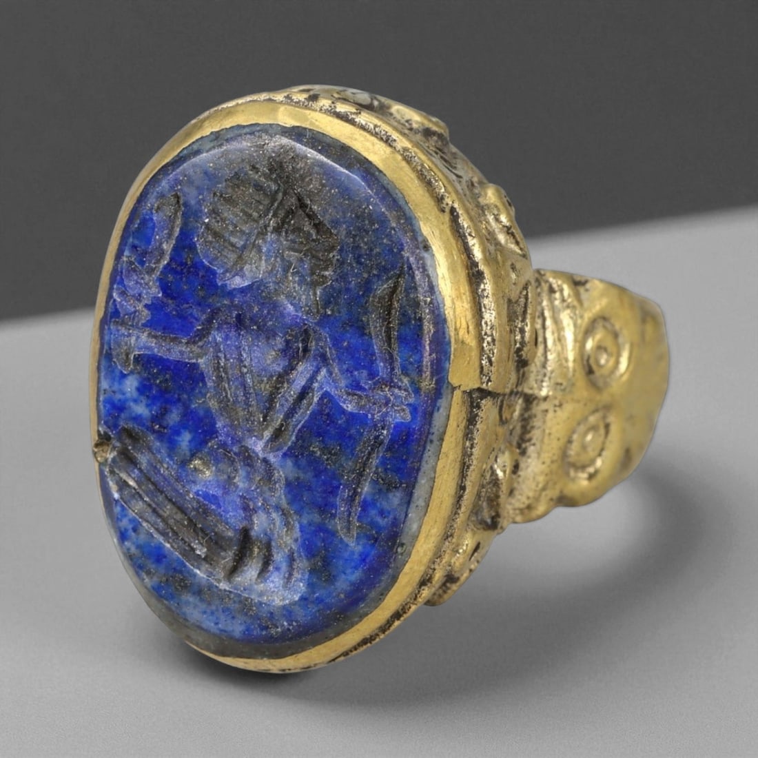 Antique Qajar Gold Gilt Intaglio Signet Ring, c. 19th-20th Century, 8.5 US: This substantial gilt ring, dating to the Qajar era of the 19th-20th century, embodies the regal aesthetic and cultural refinement of Persian jewelry traditions. The bezel is set with an engraved inta