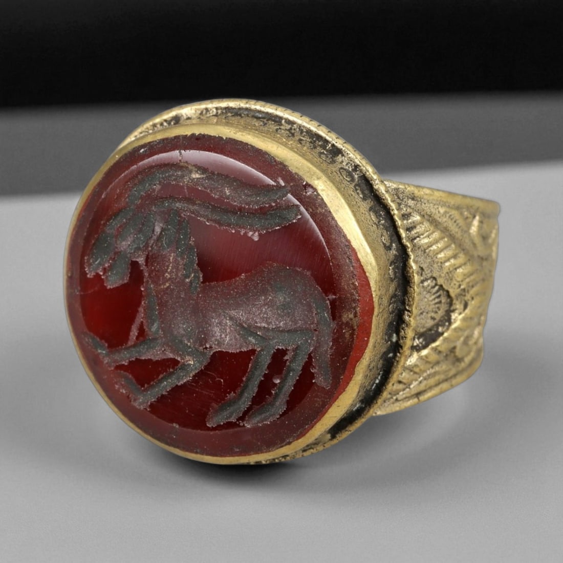 Antique Qajar Gold Gilt Intaglio Signet Ring, c. 19th-20th Century, 7.5 US: This substantial gilt ring, dating to the Qajar era of the 19th-20th century, embodies the regal aesthetic and cultural refinement of Persian jewelry traditions. The bezel is set with an engraved inta