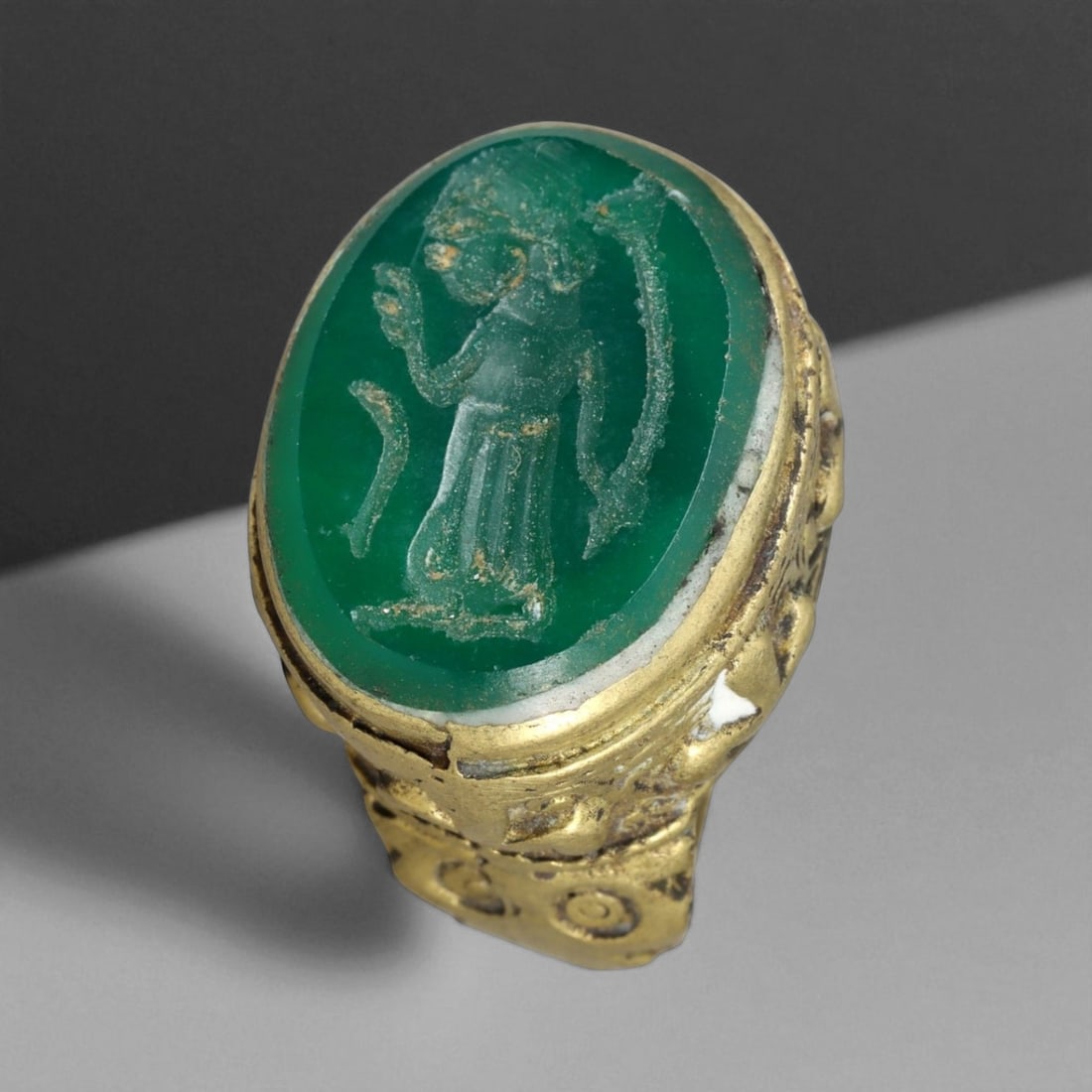 Antique Qajar Gold Gilt Intaglio Signet Ring, c. 19th-20th Century, 7.5 US: This substantial gilt ring, dating to the Qajar era of the 19th-20th century, embodies the regal aesthetic and cultural refinement of Persian jewelry traditions. The bezel is set with an engraved inta