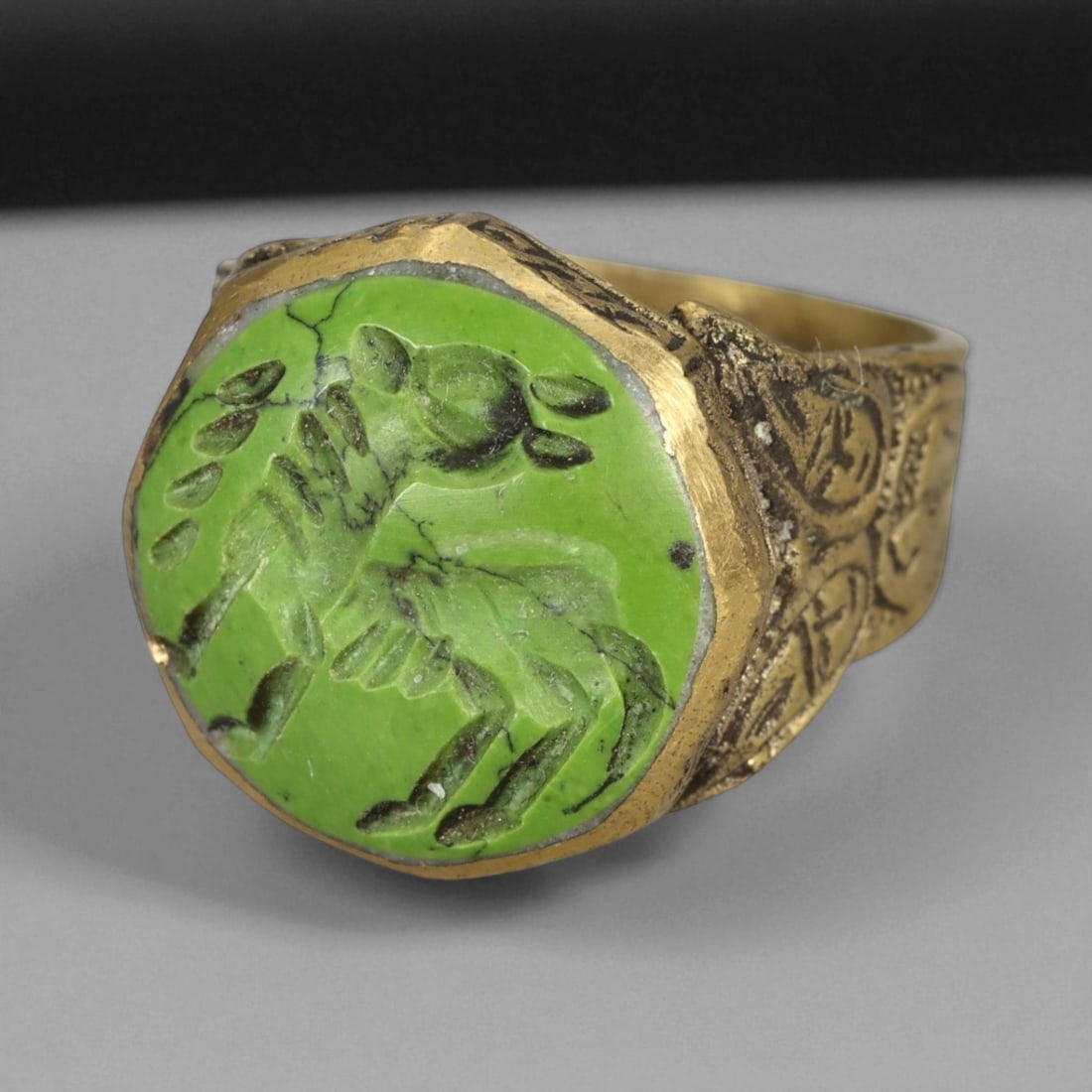 Antique Qajar Gold Gilt Intaglio Signet Ring, c. 19th-20th Century, 9 US: This substantial gilt ring, dating to the Qajar era of the 19th-20th century, embodies the regal aesthetic and cultural refinement of Persian jewelry traditions. The bezel is set with an engraved inta