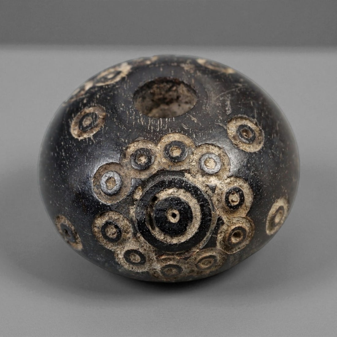 Ancient Medieval Nishapur Silk Road Bone Spindle Whorl, c. 9th-11th Century CE, 1.9cm: This finely carved spindle whorl originates from Nishapur, an important Silk Road city in medieval northeastern Iran, dating to approximately the 9th-11th century CE. Such spindle whorls were essentia