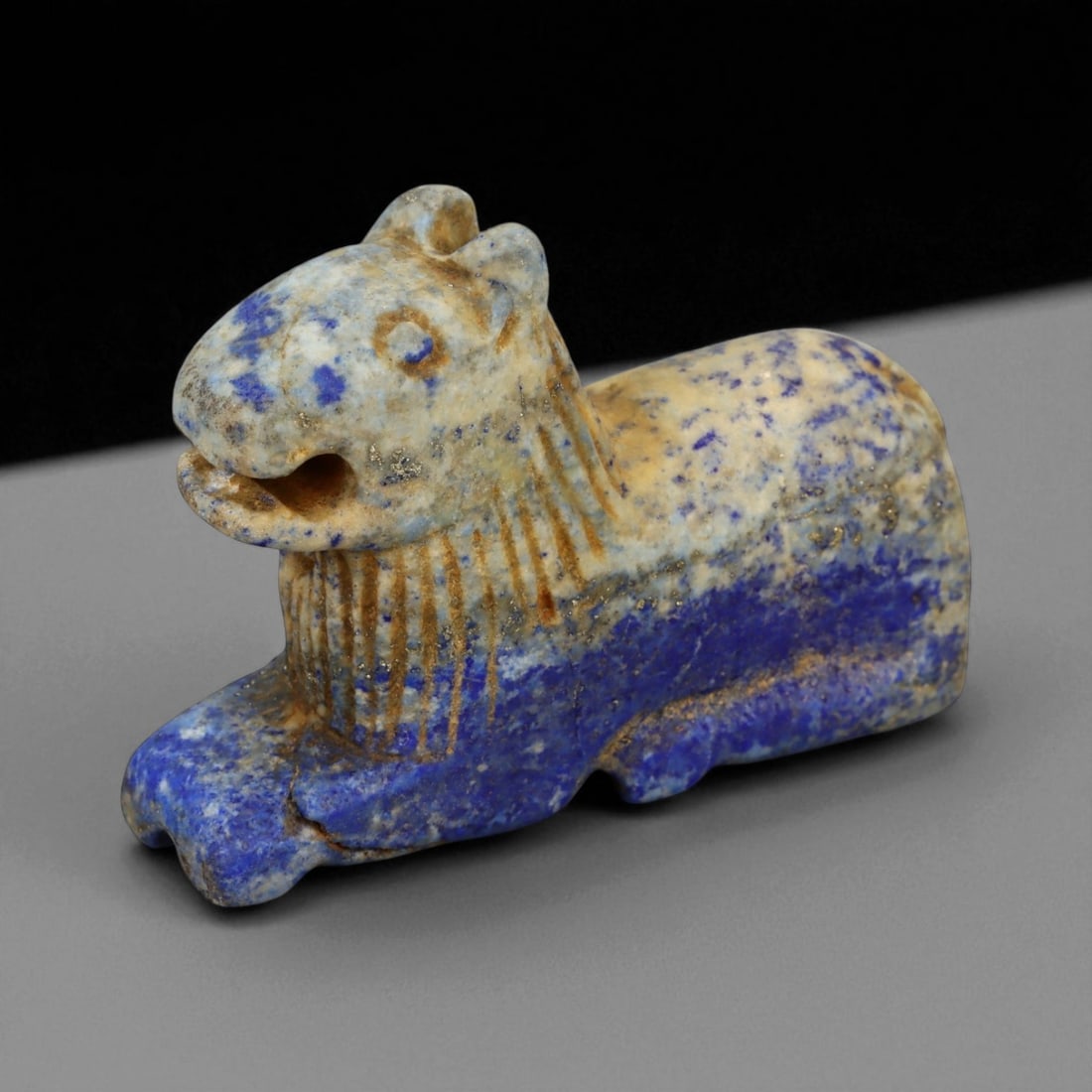 Ancient Bactrian Lapis Lazuli Lion Effigy, c. 2nd-1st Millennium BCE, L 6cm: This striking lapis lazuli effigy, carved in the form of a recumbent lion, originates from ancient Bactria, circa 2nd-1st millennium BCE. Sculpted from vibrant blue lapis lazuli streaked with veins of