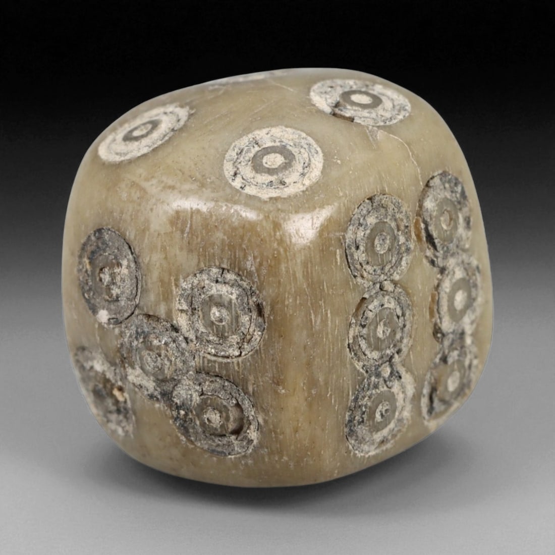 Ancient Roman Bone Dice with Ring-and-Dot Motifs, c. 1st-3rd Century CE, 1.2cm: This ancient Roman gaming die, carved from bone, dates to the 1st-3rd century CE, during the height of the Roman Empire. The cube is intricately engraved with the traditional ring-and-dot motifs used 