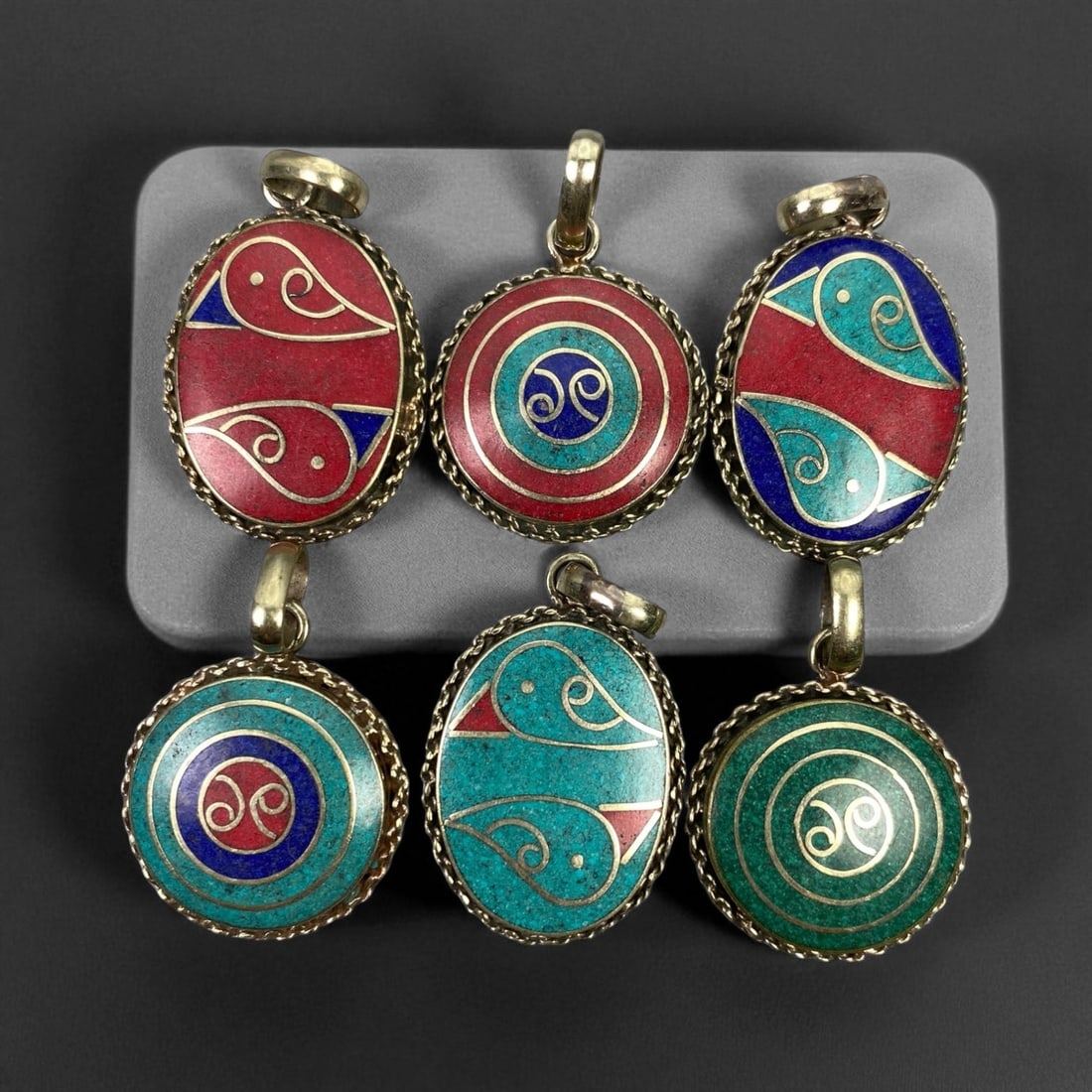 Vintage Himalayan Tribal Pendants, Lot of 6, c. 20th Century, 3-4 cm: These vintage Himalayan pendants capture the spirit and artistry of traditional jewelry from the highlands of Tibet and Nepal. Crafted with vibrant inlay work and detailed metal framing, they exemplif