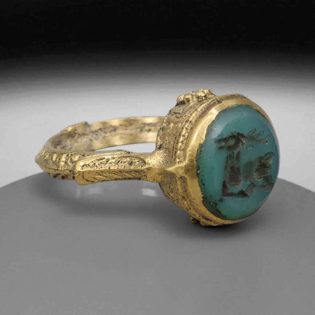 Antique Qajar Gold Gilt Intaglio Signet Ring, c. 19th-20th Century, 9.5 US: This substantial gilt ring, dating to the Qajar era of the 19th-20th century, embodies the regal aesthetic and cultural refinement of Persian jewelry traditions. The bezel is set with an engraved inta