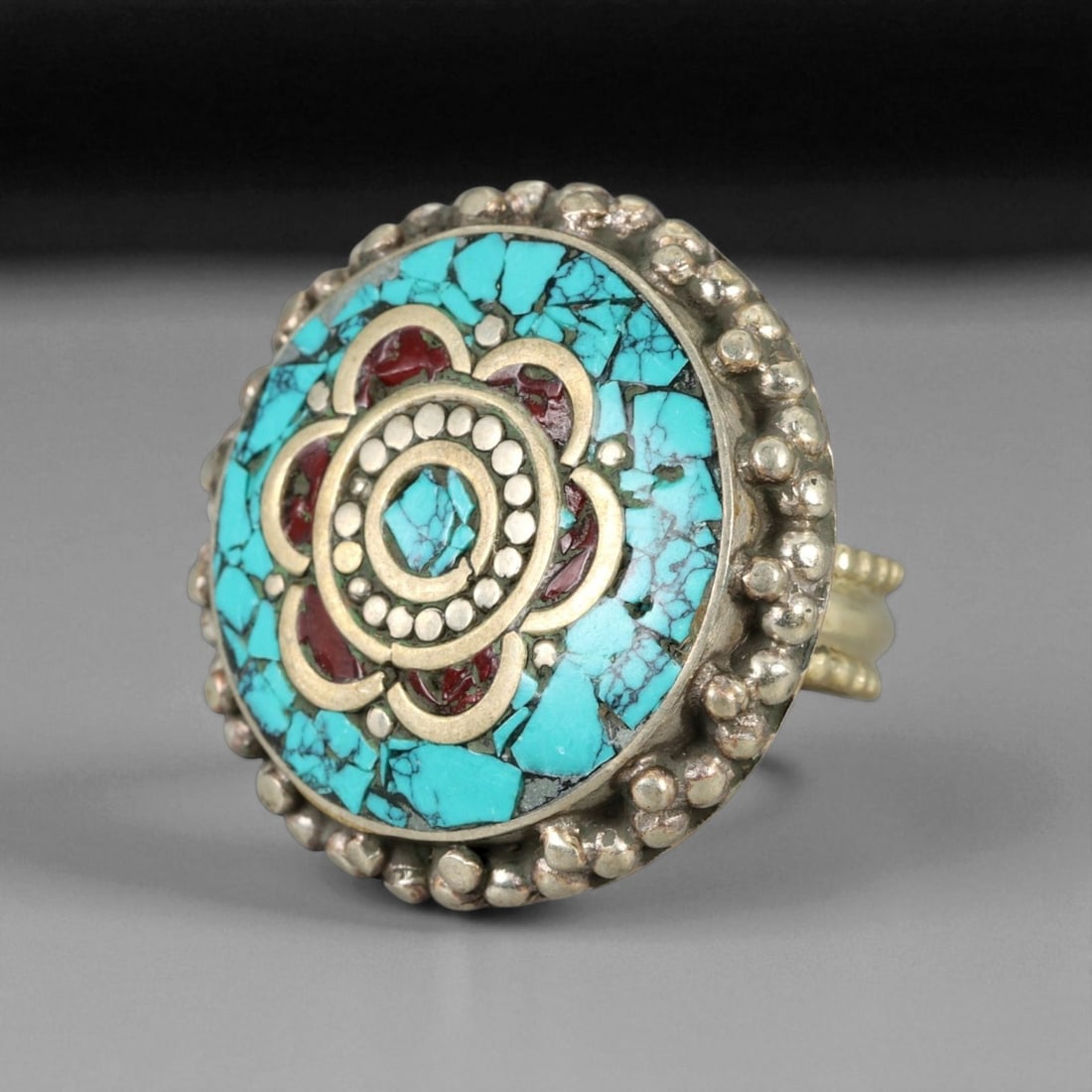 Vintage Himalayan Tibetan Turquoise Coral Inlay Silver Ring, 20th Century, US 9.25: This vintage Himalayan Tibetan ring is a striking example of traditional 20th century jewelry, showcasing a vibrant turquoise and coral inlay arranged in a mandala-like floral pattern. The bezel is bo