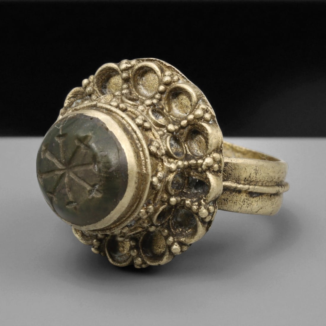 Antique Qajar Gold Gilt Intaglio Signet Ring, c. 19th-20th Century, 8 US: This substantial gilt ring, dating to the Qajar era of the 19th-20th century, embodies the regal aesthetic and cultural refinement of Persian jewelry traditions. The bezel is set with an engraved inta