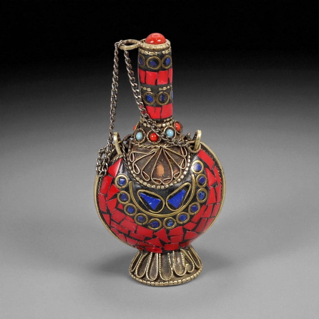 Vintage Himalayan Tribal Coral, Lapis, and Turquoise Brass Perfume Flask , 20th Century, 8cm: This magnificent shaped perfume flask embodies the ornate craftsmanship and spiritual symbolism of Himalayan tribal art. Crafted in brass and richly adorned with mosaic inlays of coral, lapis lazuli,