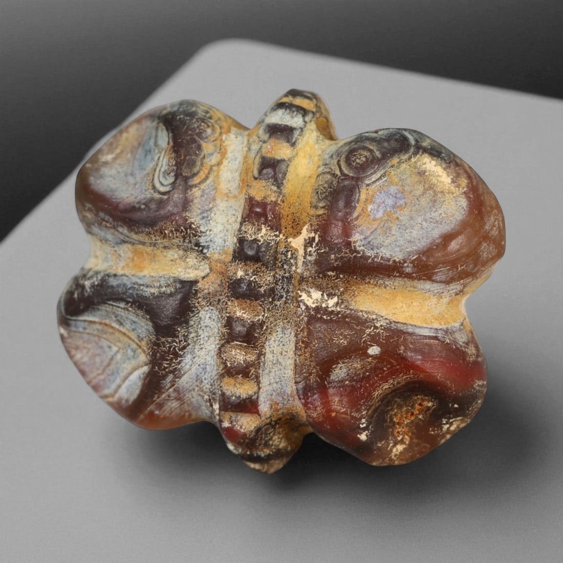 Ancient Mitannian Fly Agate Amulet, c. 15th-13th Century BCE 2.2cm: This striking fly amulet, carved from rich banded agate in tones of amber, ivory, and charcoal, dates to the Mitannian Kingdom of northern Mesopotamia, circa 15th-13th century BCE. The fly was a poten
