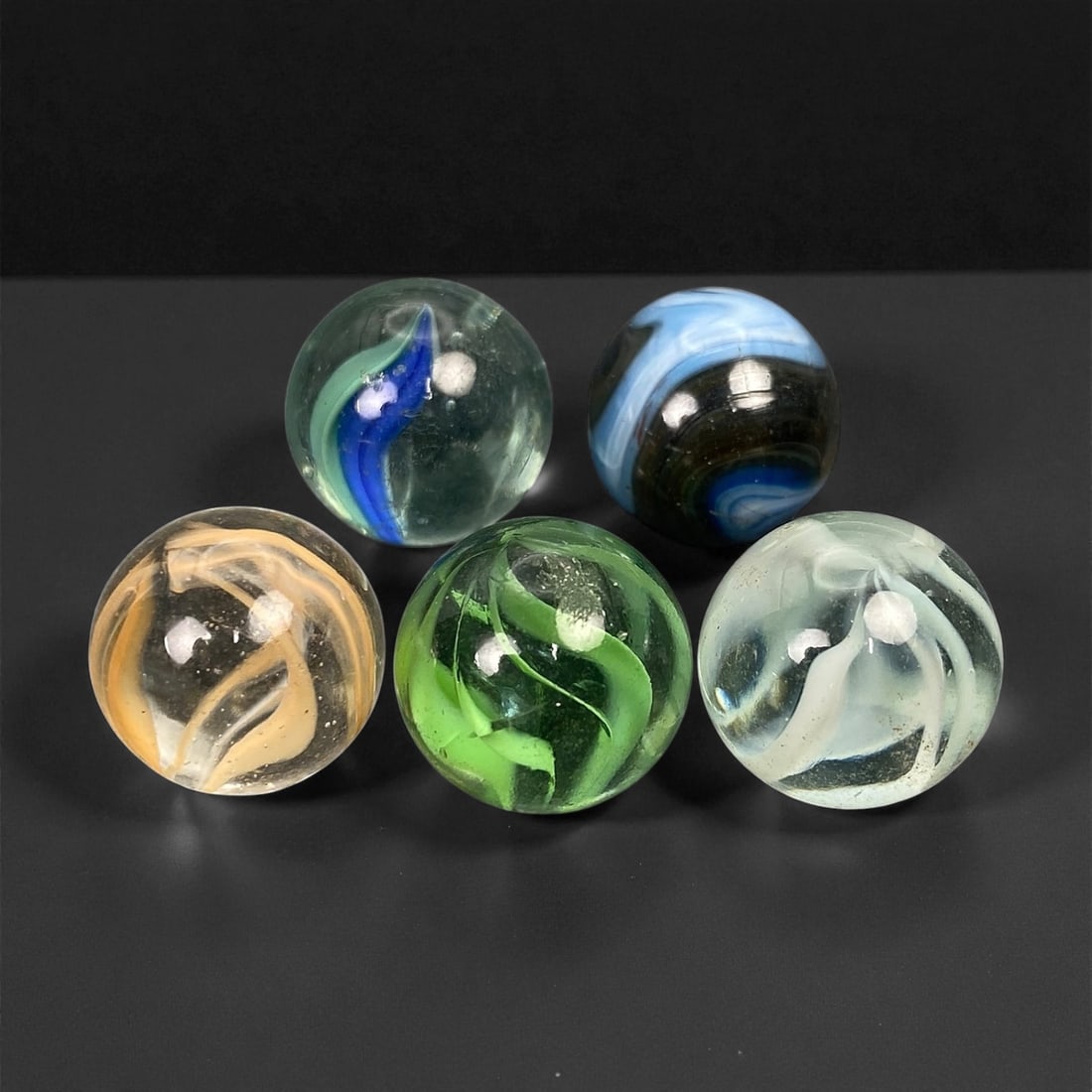Vintage Glass Marbles Lot, Mid-20th Century, 1.5cm: This charming lot of vintage glass marbles, dating from the mid-20th century, reflects the artistry and playfulness of early handmade and molded glass craftsmanship. These marbles were produced during