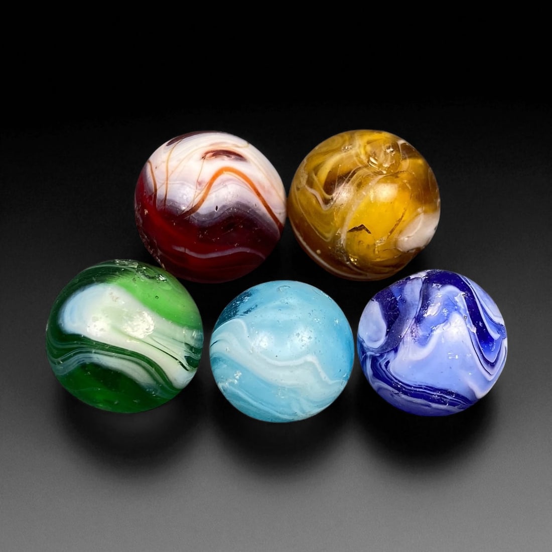 Vintage Glass Marbles Lot, Mid-20th Century, 1.3-1.7cm: This charming lot of vintage glass marbles, dating from the mid-20th century, reflects the artistry and playfulness of early handmade and molded glass craftsmanship. These marbles were produced during