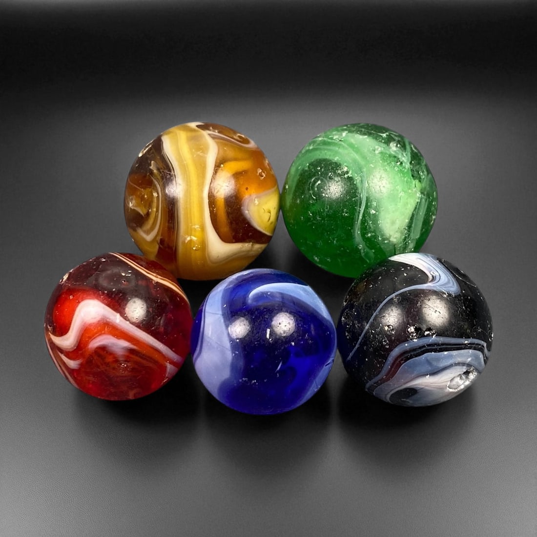 Vintage Glass Marbles Lot, Mid-20th Century, 1.8-2.2cm: This charming lot of vintage glass marbles, dating from the mid-20th century, reflects the artistry and playfulness of early handmade and molded glass craftsmanship. These marbles were produced during
