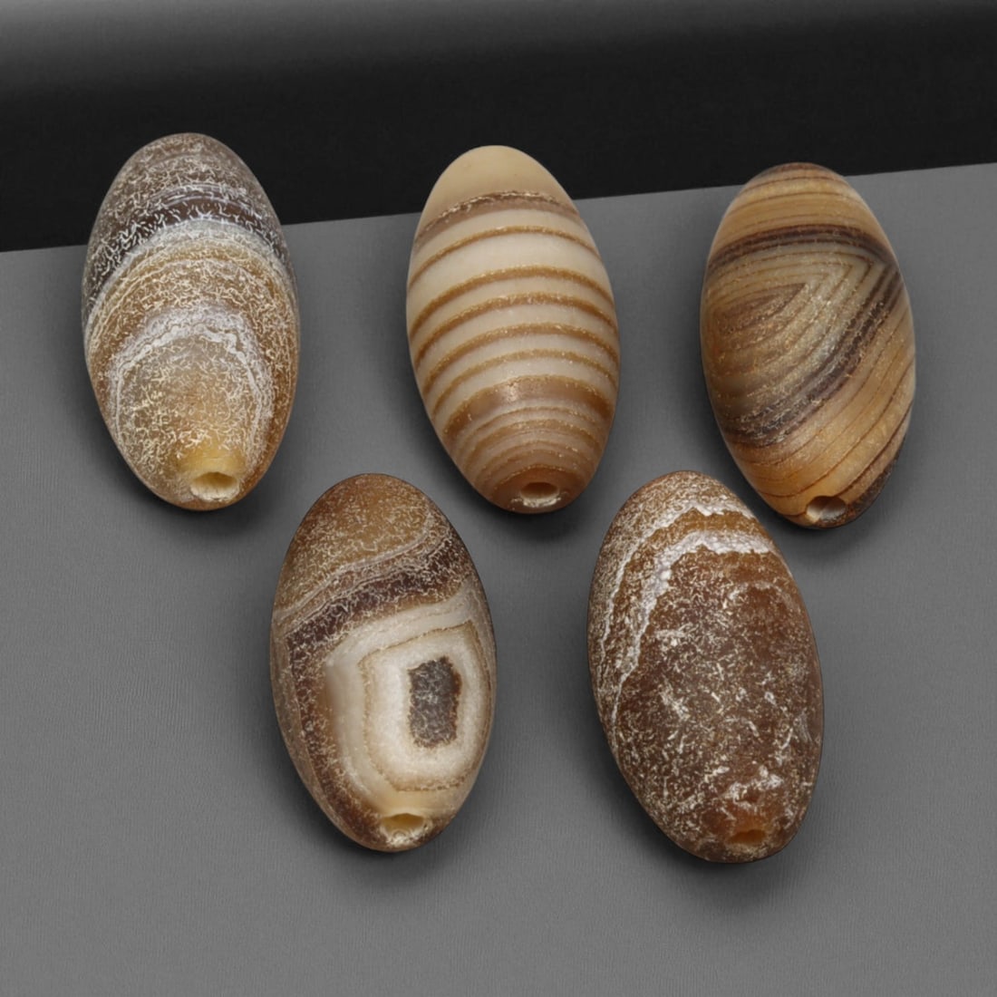 Antique Tibetan Banded Agate Beads, c. 19th-Early 20th Century, 1.5cm: This elegant group of antique Tibetan banded agate beads dates to the 19th-early 20th century and showcases the refined lapidary tradition of the Himalayan region. Each bead is hand-carved and careful