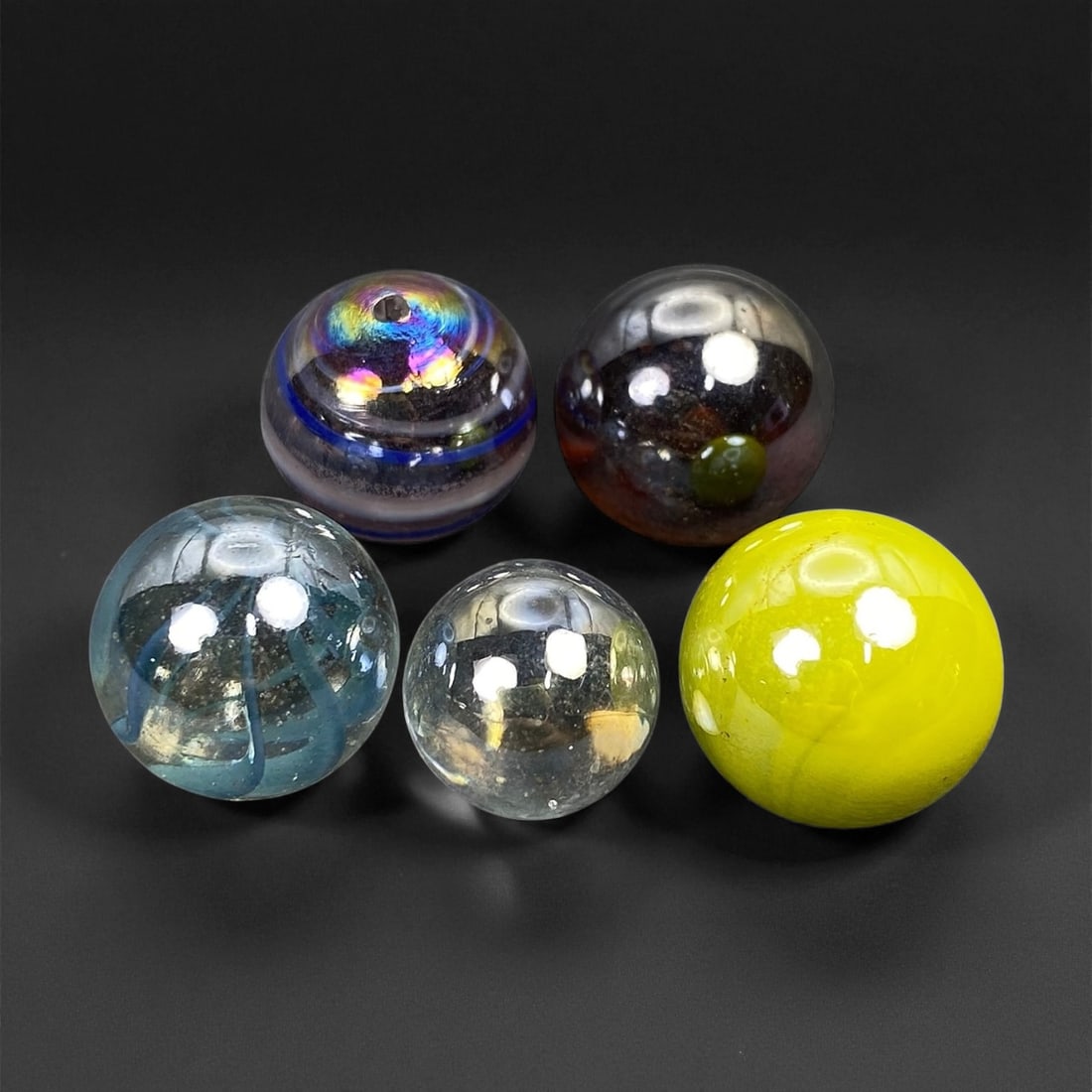 Vintage Glass Marbles Lot, Mid-20th Century, 1.3-1.6cm: This charming lot of vintage glass marbles, dating from the mid-20th century, reflects the artistry and playfulness of early handmade and molded glass craftsmanship. These marbles were produced during