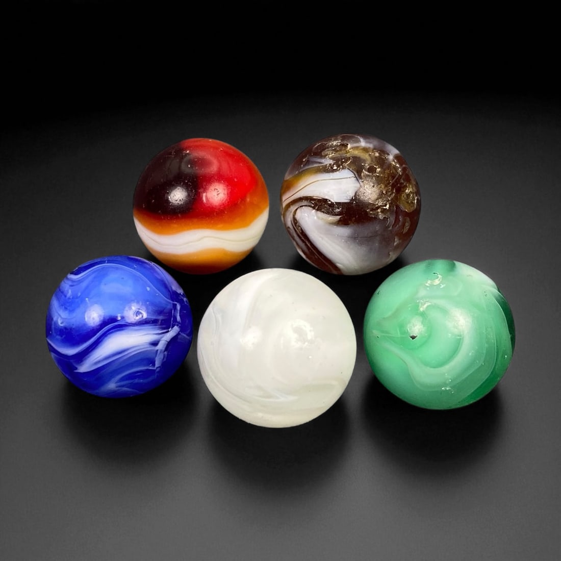 Vintage Glass Marbles Lot, Mid-20th Century, 1.6-1.7cm: This charming lot of vintage glass marbles, dating from the mid-20th century, reflects the artistry and playfulness of early handmade and molded glass craftsmanship. These marbles were produced during