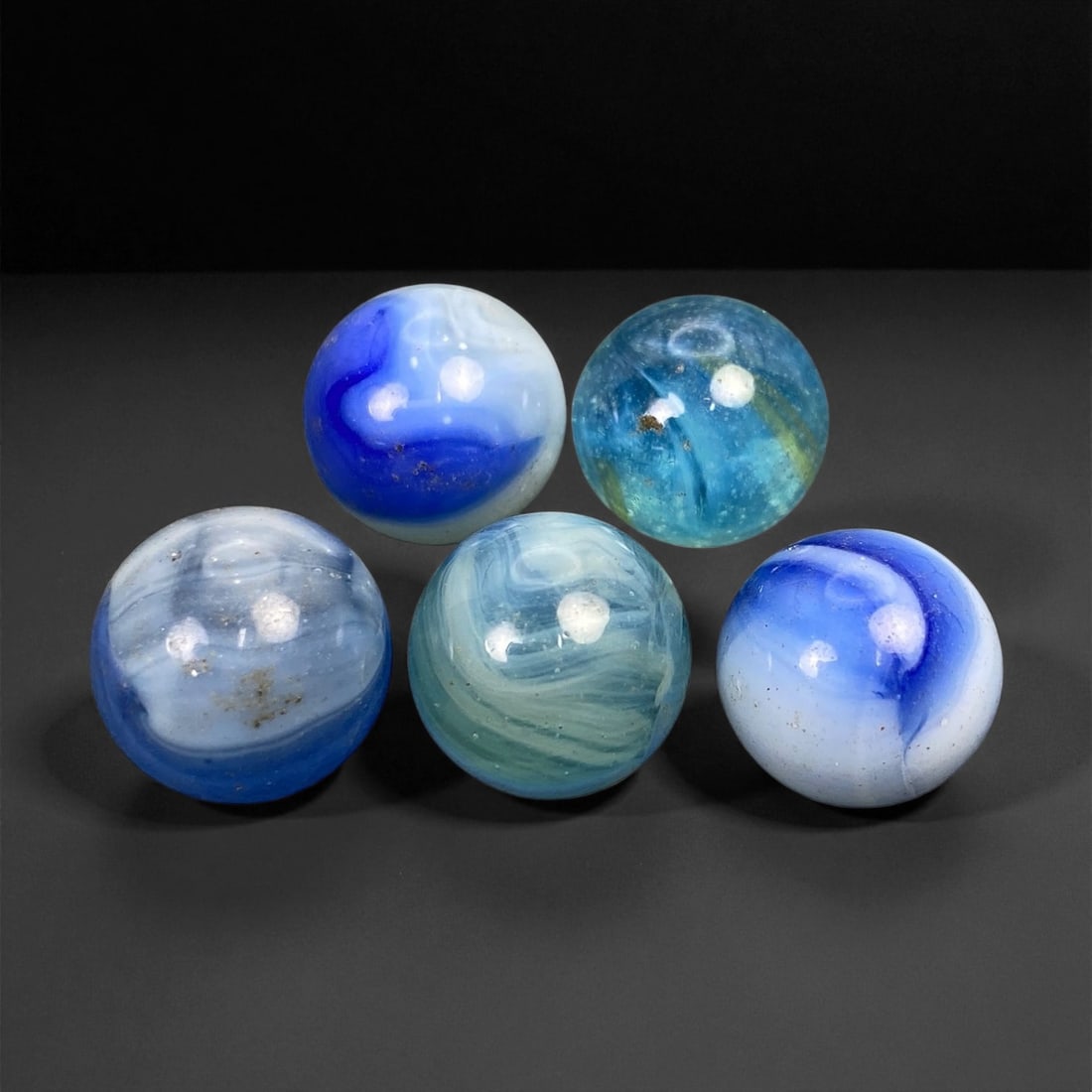 Vintage Glass Marbles Lot, Mid-20th Century, 1.5-1.6cm: This charming lot of vintage glass marbles, dating from the mid-20th century, reflects the artistry and playfulness of early handmade and molded glass craftsmanship. These marbles were produced during