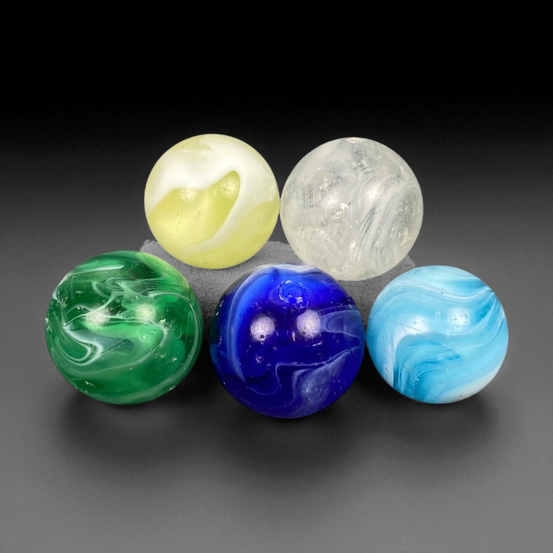 Vintage Glass Marbles Lot, Mid-20th Century, 1.5-1.6cm: This charming lot of vintage glass marbles, dating from the mid-20th century, reflects the artistry and playfulness of early handmade and molded glass craftsmanship. These marbles were produced during