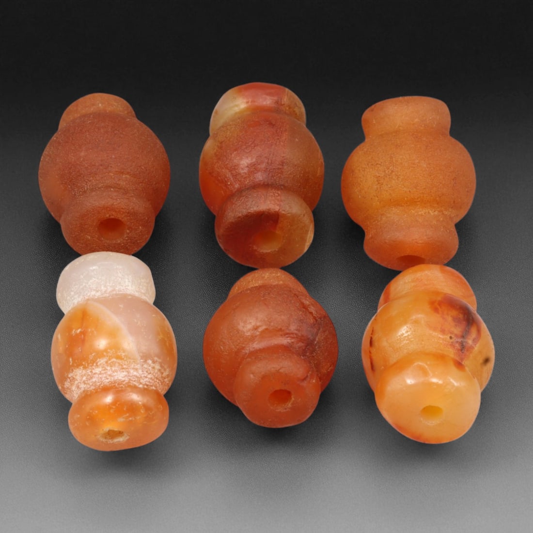 Ancient Medieval South Indian Chola Collared Carnelian Beads, c. 9th-12th Century CE, 1.9-2.1cm: This elegant group of collared carnelian beads dates to the Chola period of South India, circa 9th-12th century CE. Each bead is hand-carved from fine translucent carnelian in shades of amber, honey, 