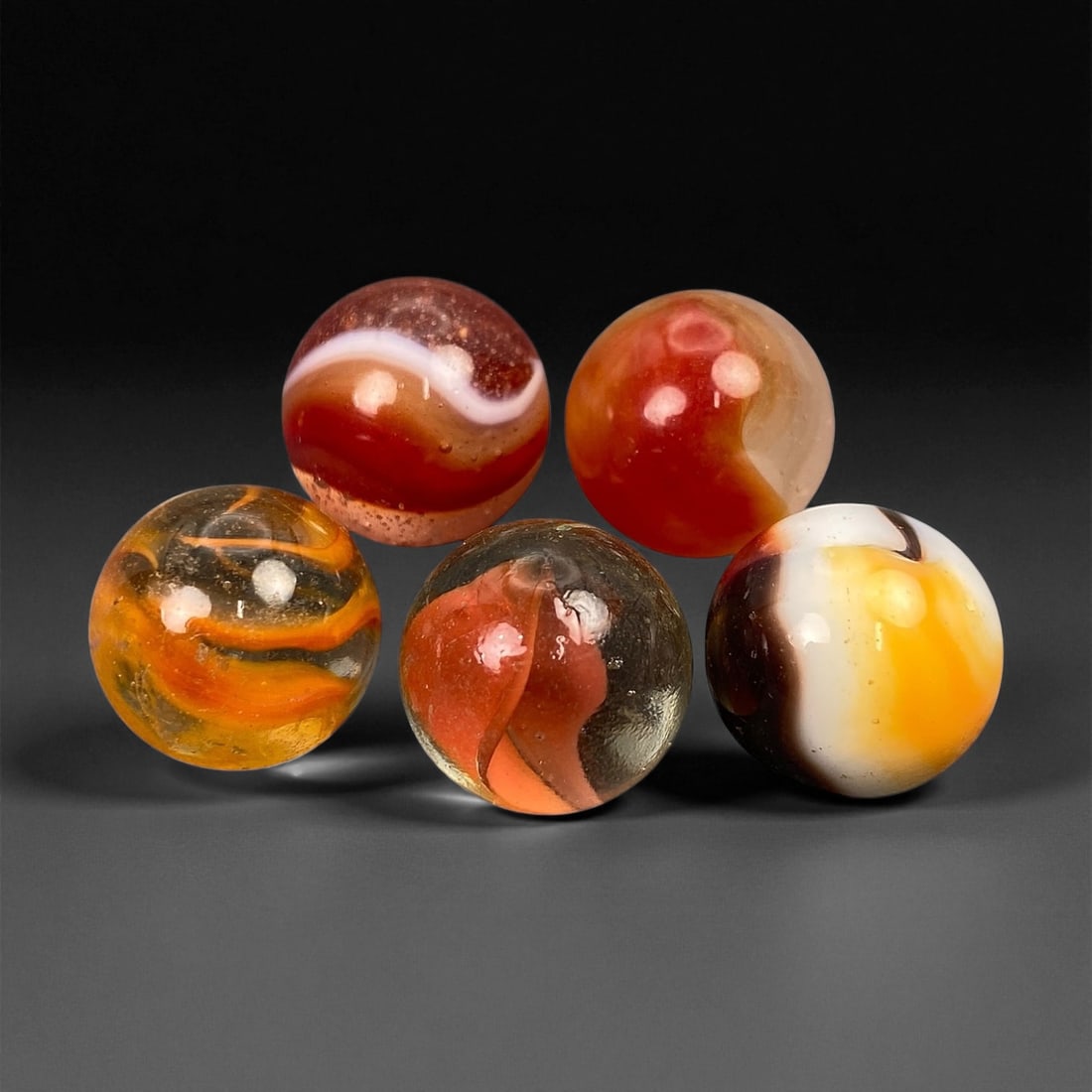 Vintage Glass Marbles Lot, Mid-20th Century, 1.5-1.6cm: This charming lot of vintage glass marbles, dating from the mid-20th century, reflects the artistry and playfulness of early handmade and molded glass craftsmanship. These marbles were produced during