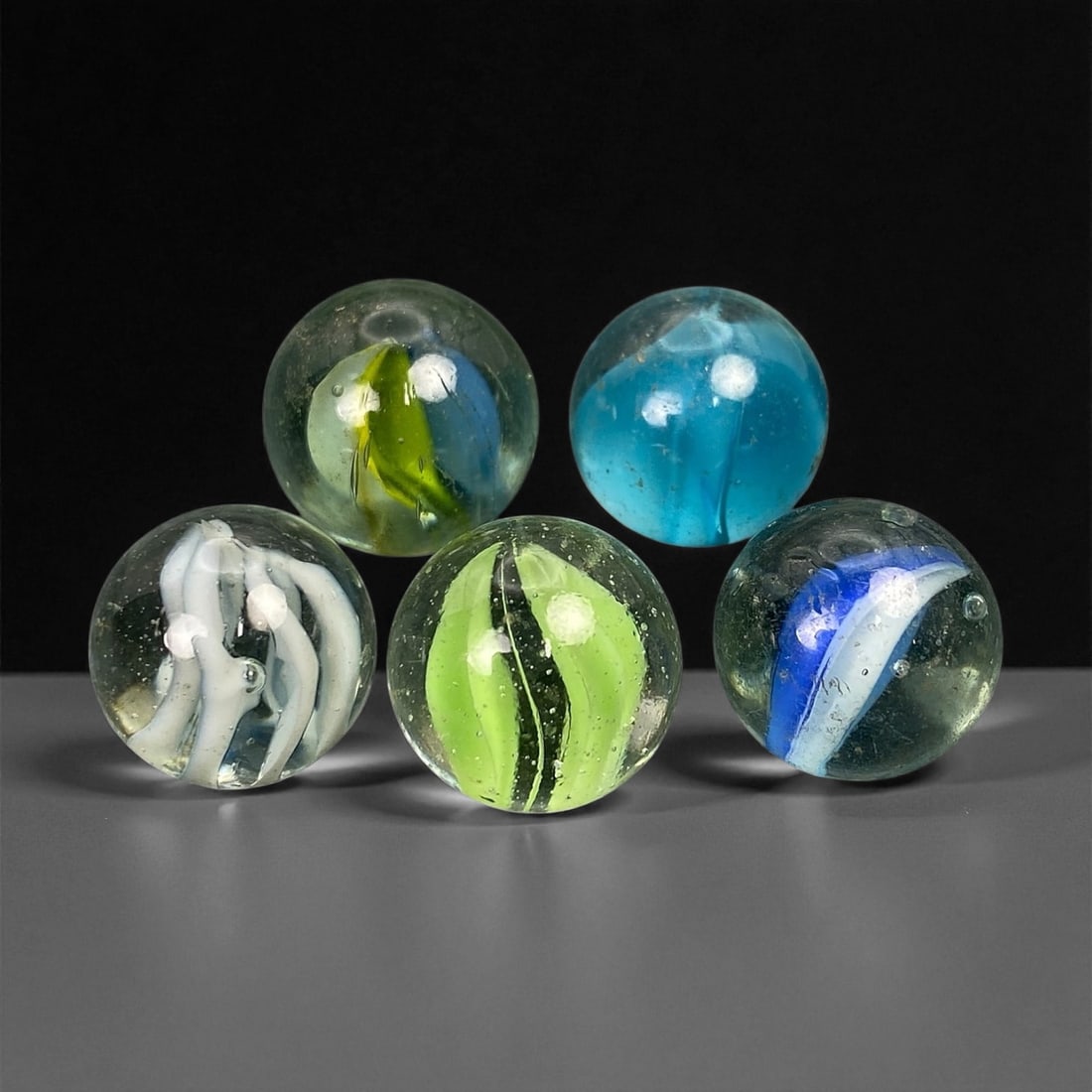 Vintage Glass Marbles Lot, Mid-20th Century, 1.5cm: This charming lot of vintage glass marbles, dating from the mid-20th century, reflects the artistry and playfulness of early handmade and molded glass craftsmanship. These marbles were produced during