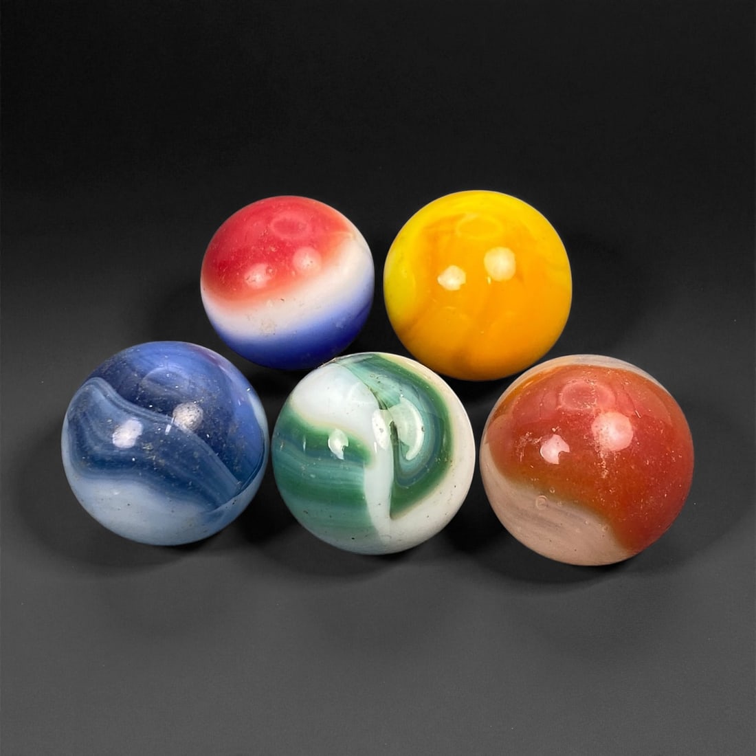 Vintage Glass Marbles Lot, Mid-20th Century, 1.4-1.6cm: This charming lot of vintage glass marbles, dating from the mid-20th century, reflects the artistry and playfulness of early handmade and molded glass craftsmanship. These marbles were produced during