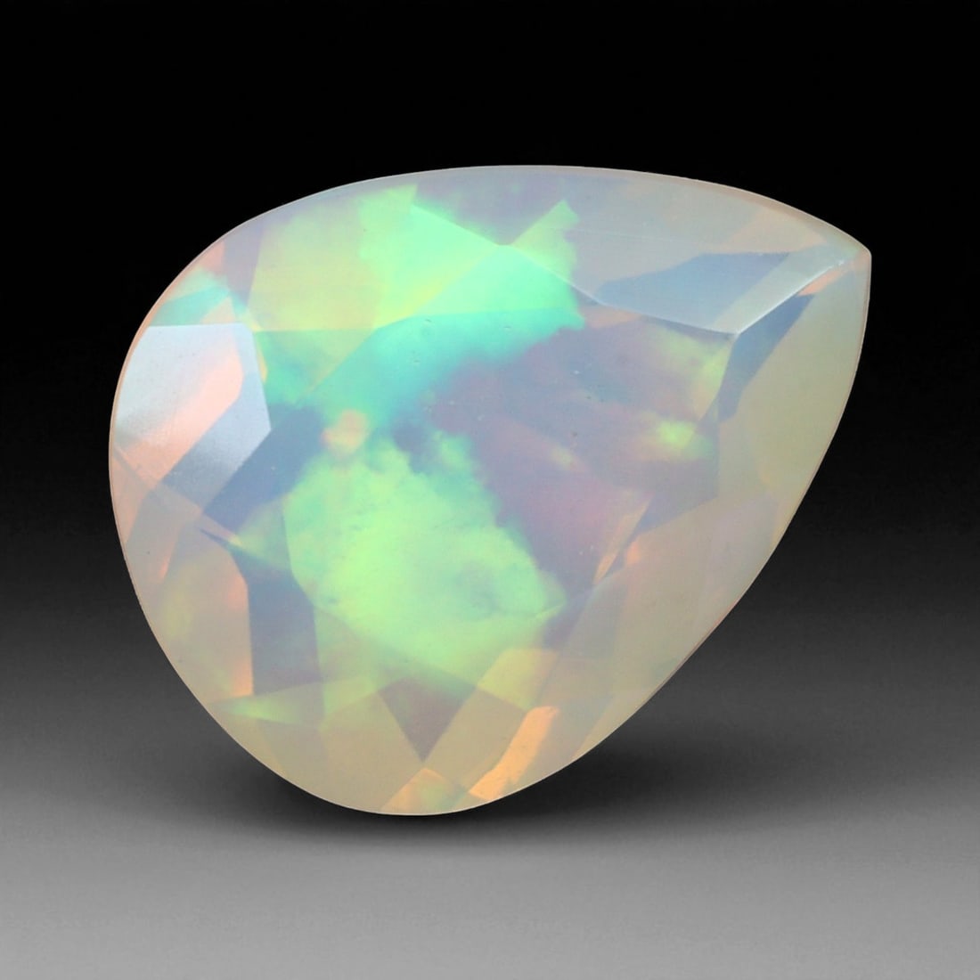 2.10 Carats Pear-Cut Faceted Welo Opal - Natural Ethiopian Stone: This graceful 11x8.5x5.4 mm Ethiopian opal radiates a soft yet vibrant play-of-color, with hues of green, orange, and rose blending harmoniously beneath its faceted pear-shaped surface. The gem displa