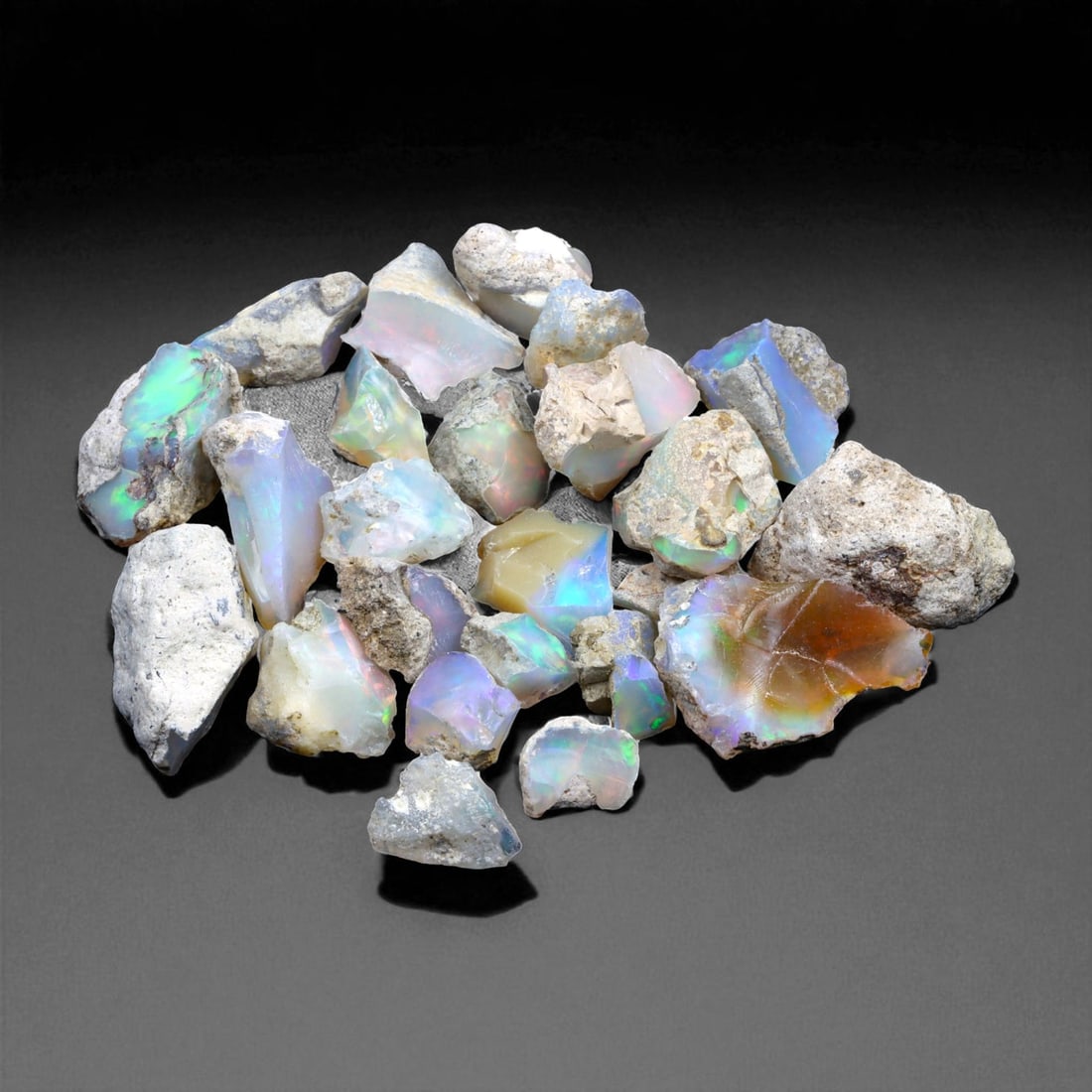 77.38 Carats Welo Opal Rough Parcel - Natural Ethiopian Stones: This striking parcel of natural Welo opal rough captures the enchanting play-of-color that has made Ethiopian material world-renowned. Displaying vivid flashes of electric green, fiery orange, neon bl