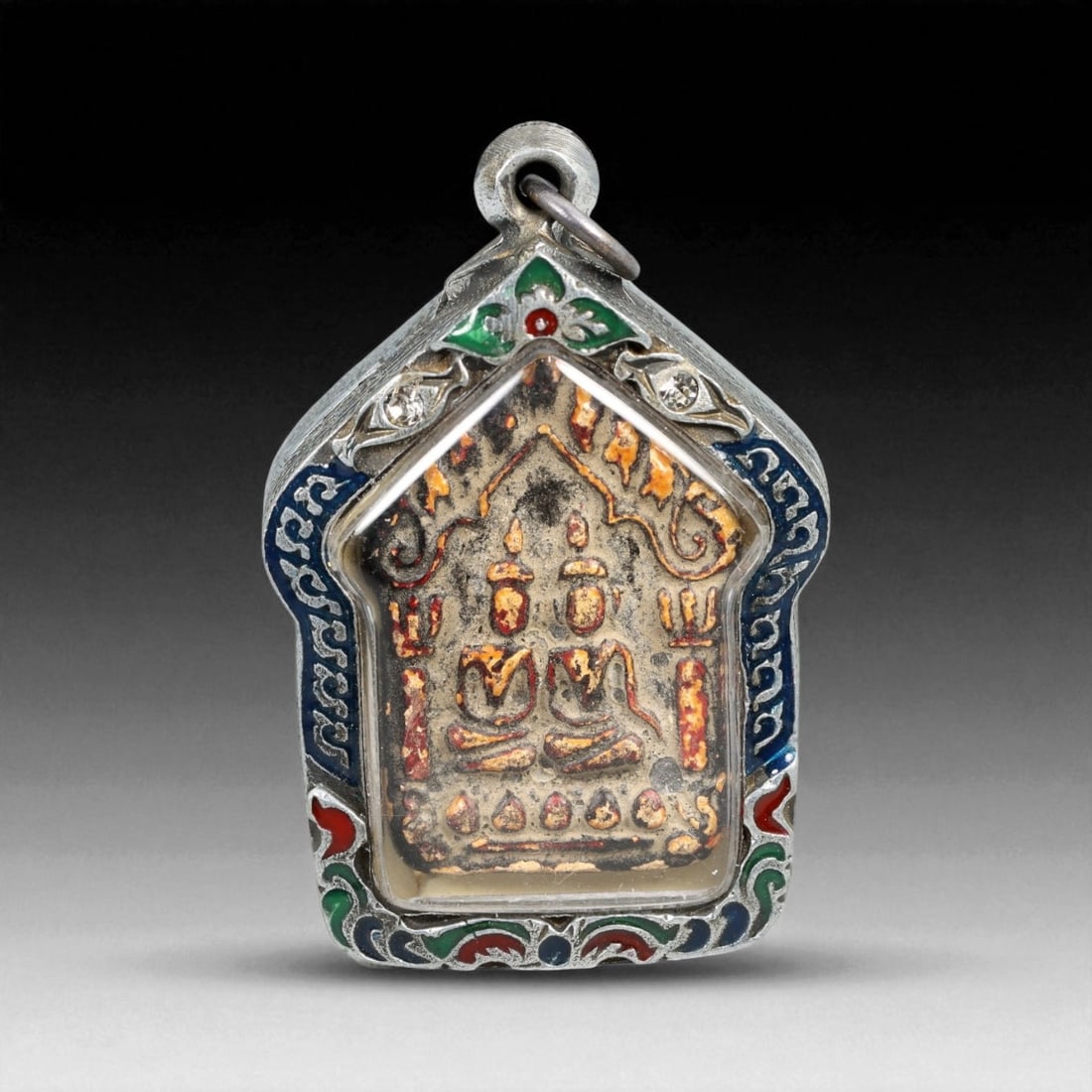 Vintage Thai Twin Buddha Clay Amulet in Ornate Temple-Arch Enamel Case, c. Mid-20th Century, 42.9g: This captivating vintage Thai amulet presents a rare dual-Buddha depiction, each seated in meditative posture beneath an elaborately sculpted temple arch. Cast in sacred clay and accented with traces