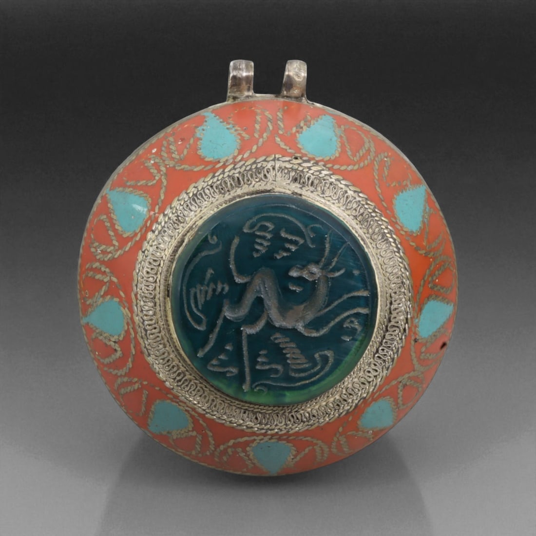 Antique Persian Enamel Silver Pendant with Stylized Gazelle, 127g: This Persian pendant embodies the elegance of enamel artistry combined with the symbolism of the gazelle, a beloved motif in Persian poetry and decorative arts. At its center lies a dark teal stone, c