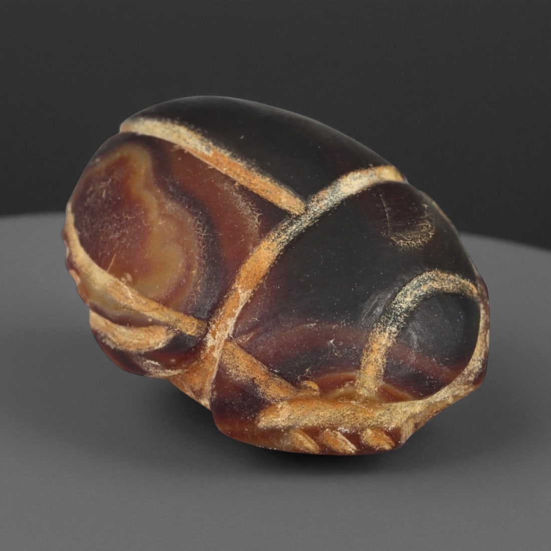Ancient Egyptian Banded Agate Scarab Amulet, c. New Kingdom 16th-11th Century BCE (2.2 cm): This beautifully carved scarab amulet, fashioned from rich banded agate, dates to Egypt's New Kingdom period-a time when scarabs served as enduring emblems of protection, transformation, and rebirth. 