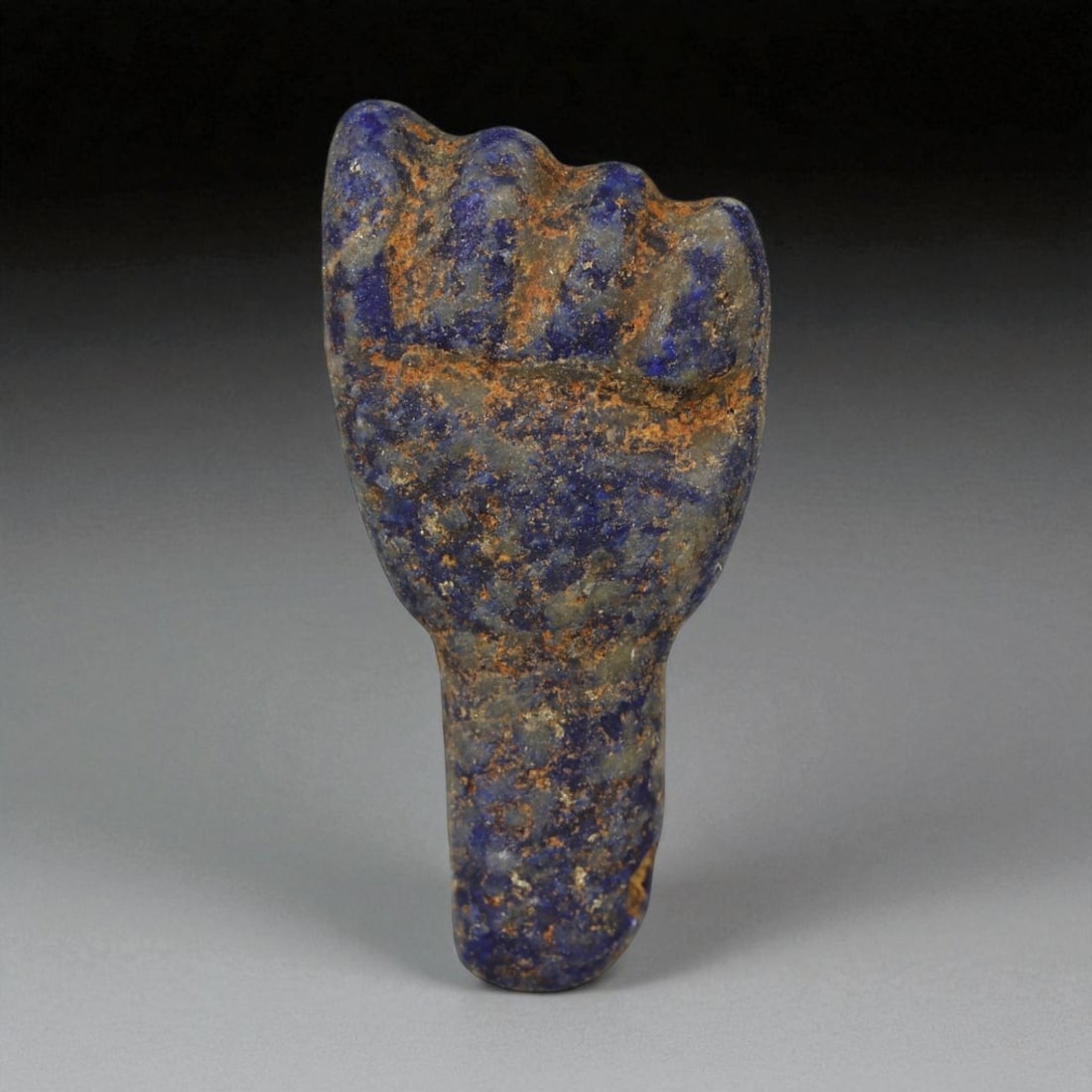 Ancient Egyptian New Kingdom Lapis Lazuli Fist Amulet, c. 1550-1069 BCE, 2.8cm: This exquisite lapis lazuli amulet, carved in the shape of a clenched fist, originates from Egypt's New Kingdom period (c. 1550-1069 BCE) - a time when symbolism and craftsmanship merged into powerful