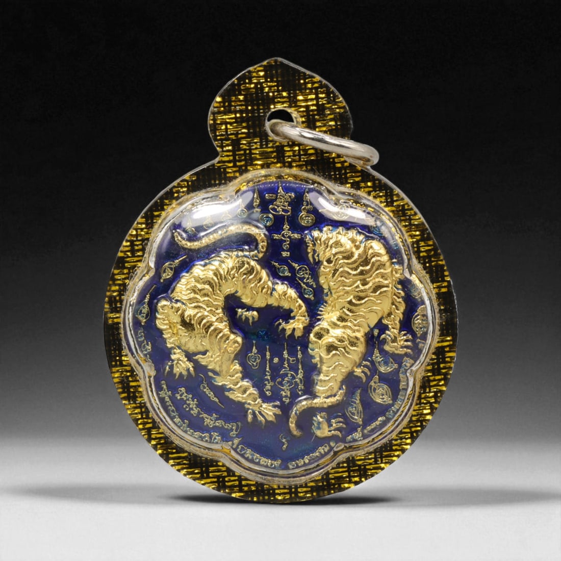 Thai Buddhist Amulet in Acrylic Casing with Gilt Relief, 4.5cm: This finely detailed Thai Buddhist amulet presents a striking balance between modern craftsmanship and sacred symbolism. Set within a clear acrylic casing that enhances its brilliance and preserves it