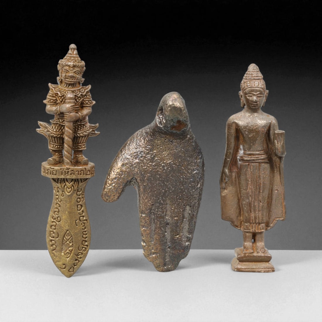 Vintage Thai Bronze Guardian and Buddha Amulet Trio, c. 20th Century (3-4 cm): This distinctive trio of vintage Thai bronze amulets offers a fascinating glimpse into the spiritual diversity and symbolic artistry of Thailand's 20th-century devotional tradition. Each piece, measur