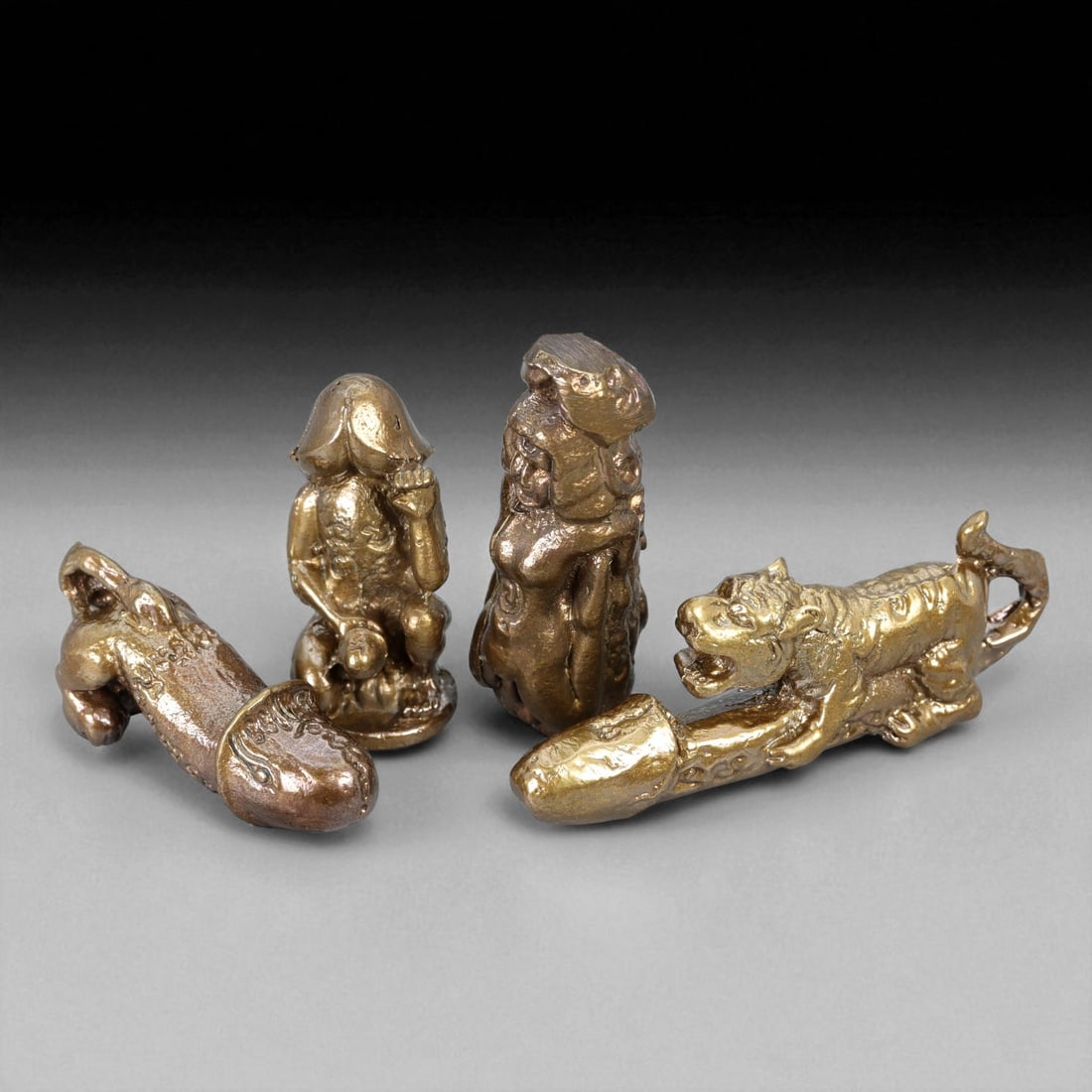 Vintage Thai Bronze Palad Khik and Hermit Amulet Set, c. 20th Century 3-5cm: This distinctive set of four vintage Thai bronze amulets reflects the fascinating intersection of spiritual devotion, folk belief, and protective symbolism within Thai Buddhist culture. Cast between 3