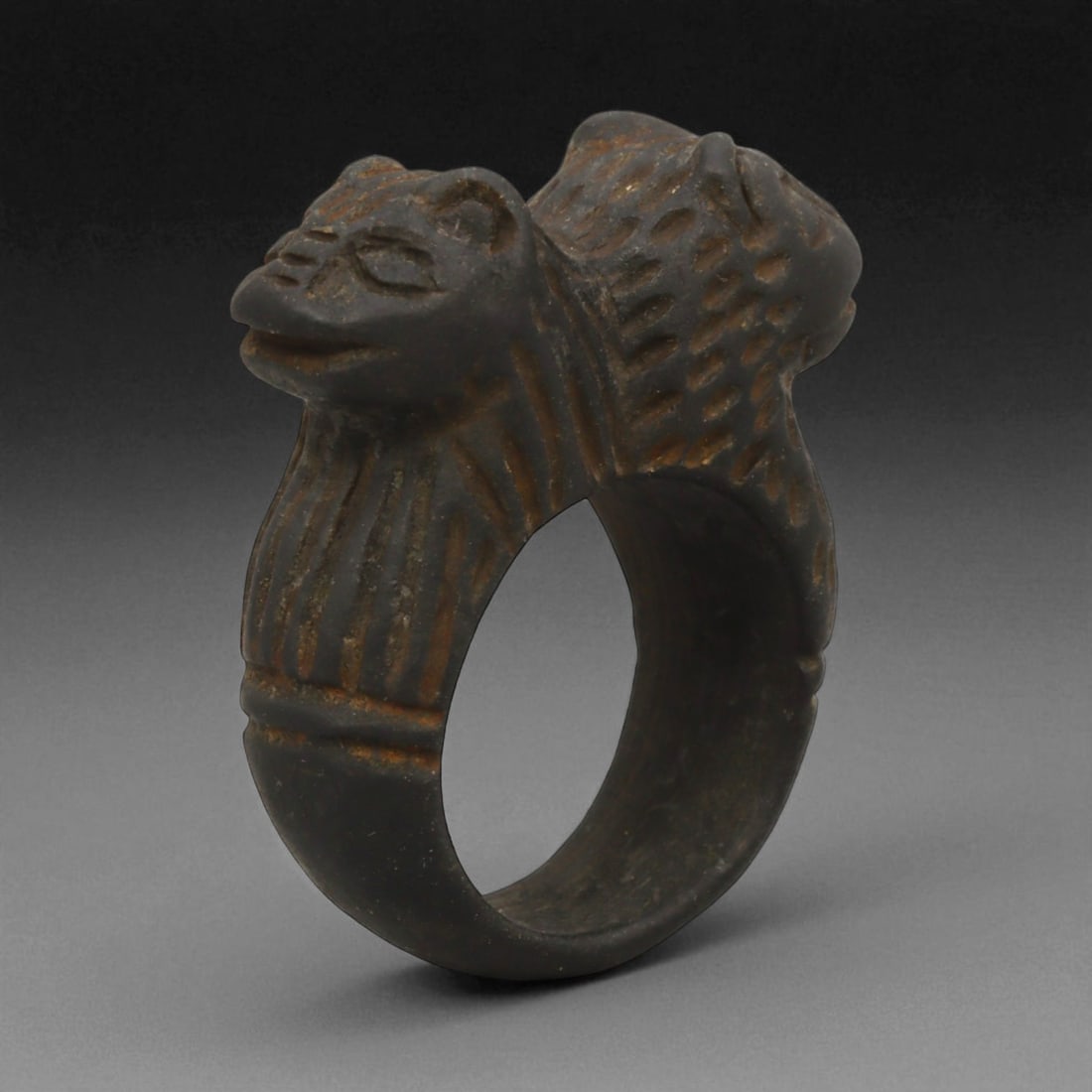 Ancient Mesopotamian Double-Lion Steatite Ring, c. 2nd Millennium BCE, 3.8 cm: This powerful stone ring, sculpted in steatite with twin lion heads, originates from the cultural heartlands of ancient Mesopotamia during the 2nd millennium BCE-a period marked by the flourishing of 