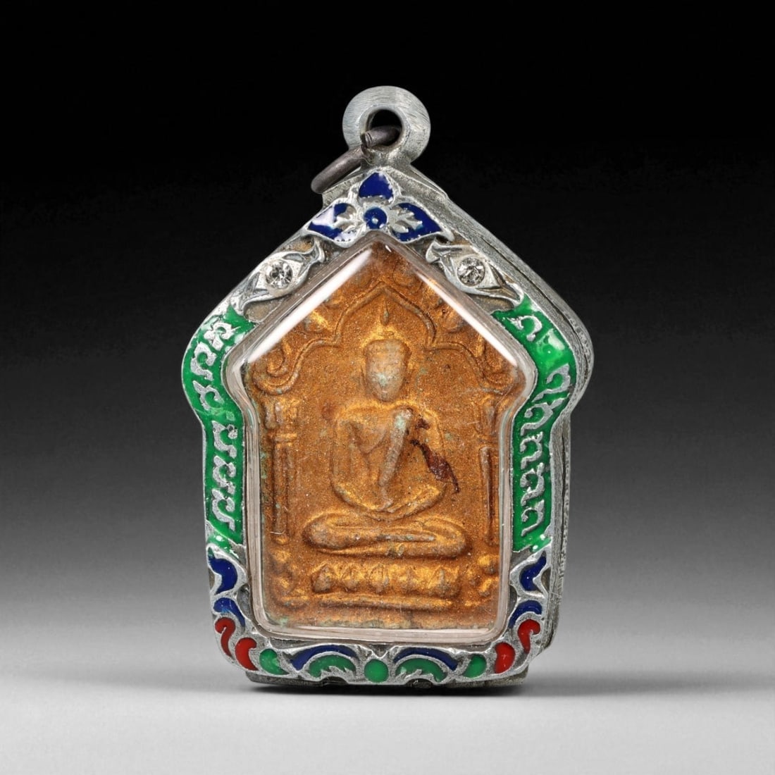 Vintage Thai Rattanakosin Buddha Amulet in Enameled Silver Case, c. 20th Century CE, 43g: This vintage Thai amulet radiates devotional charm and historical resonance. Crafted during the 20th century CE, it depicts the Buddha seated in serene meditation within a stylized temple arch. The fi