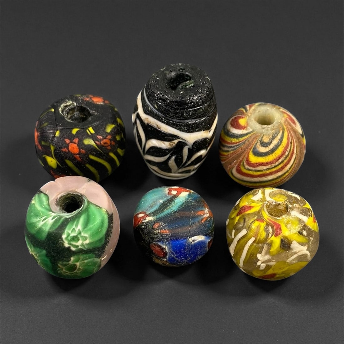 Antique Venetian Millefiori Glass Trade Beads, c. 19th Century, 1.7-2.5cm: This vibrant assemblage of five antique Venetian glass beads captures the height of Murano's decorative artistry during the 19th century. Created using the millefiori and chevron techniques, these bea