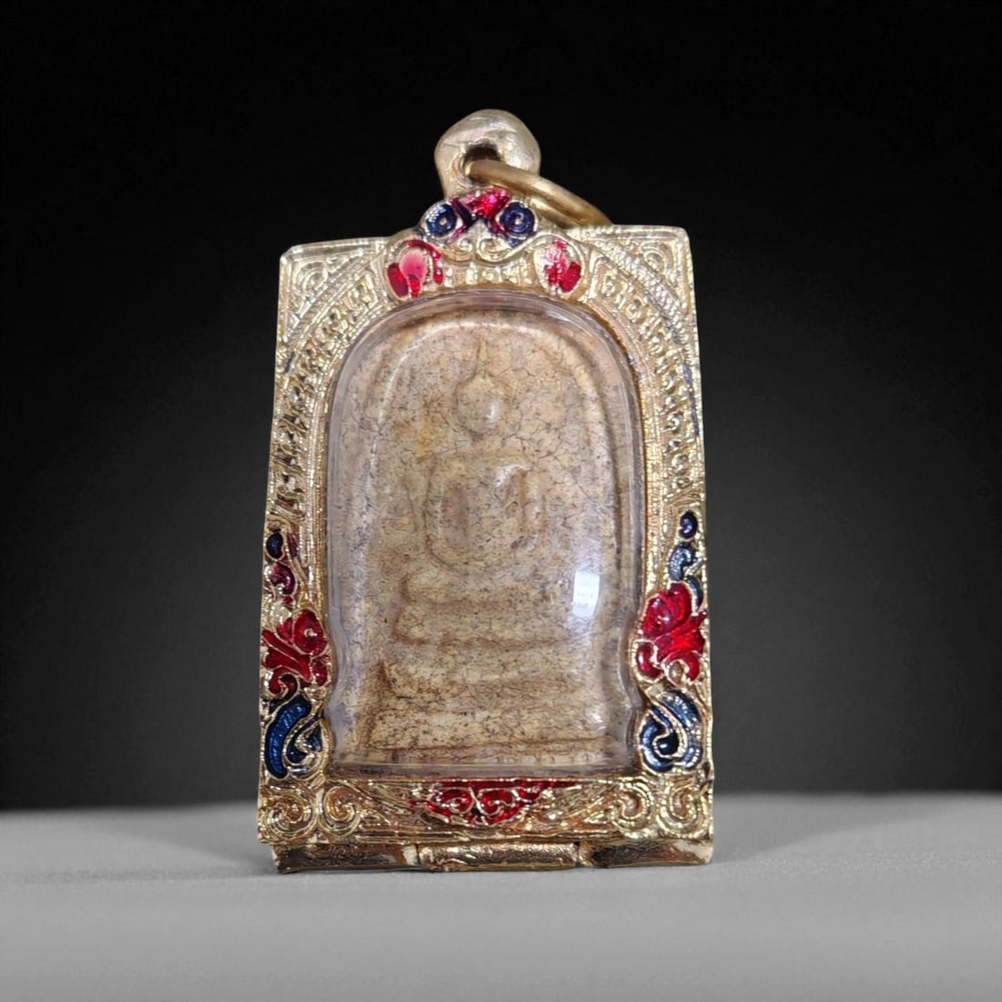 Antique Thai Rattanakosin Buddha Image Clay Amulet in Gilt Enamel Case, c. 19th-20th Century,: This antique Thai amulet depicts the seated Buddha in meditation, enclosed within a graceful arched niche. Crafted in clay during the Rattanakosin Kingdom era (19th-20th century), it represents the re