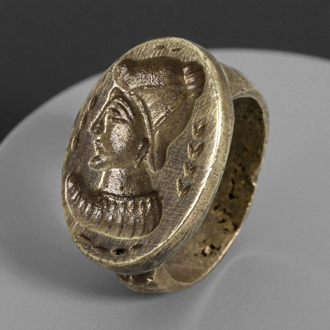 Antique Qajar Era Copper Alloy Intaglio Ring with Portrait Bust, c. 19th-20th Century, 10g: This antique copper alloy ring dates to the Qajar era of Persia, a period celebrated for its vibrant fusion of tradition and innovation in the decorative arts. The bezel is engraved in high relief wit