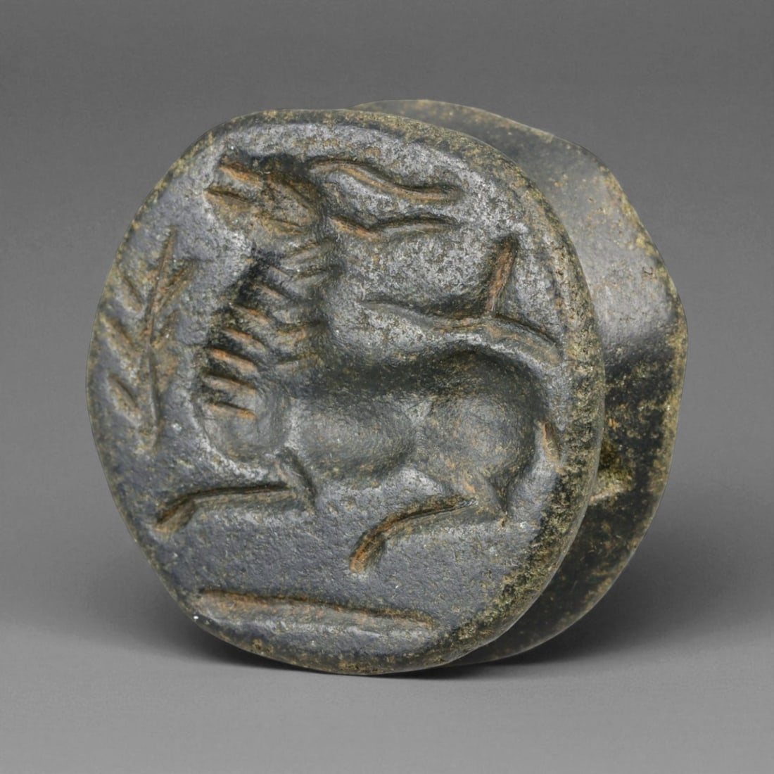 Ancient Mesopotamian Kassite Black Stone Double-Convex Amulet with Ibex, 14th-12th Century BCE 21g: This finely carved double-convex black stone amulet, measuring 3 cm (1.2 in) across and weighing 21 g (0.74 oz), belongs to the Kassite period of Mesopotamia, a dynasty that ruled Babylonia between th