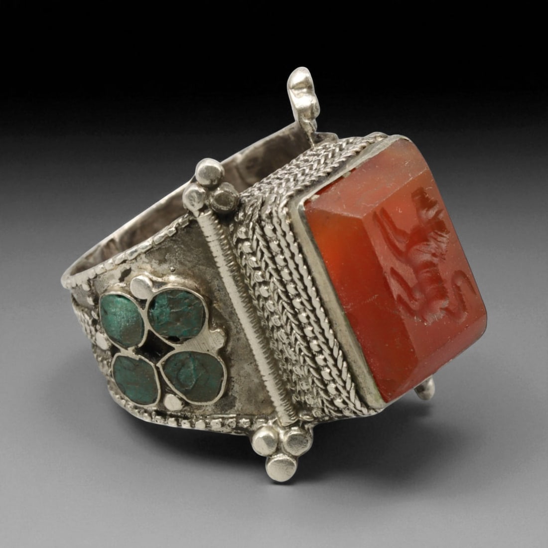 Antique Persian Lion Intaglio Carnelian and Turquoise Silver Ring, c. 19th-20th Century, US 9.5: This impressive antique Persian ring showcases the grandeur and symbolism of Qajar-era craftsmanship. The bold, elevated carnelian bezel bears a finely engraved lion intaglio-an enduring emblem of str