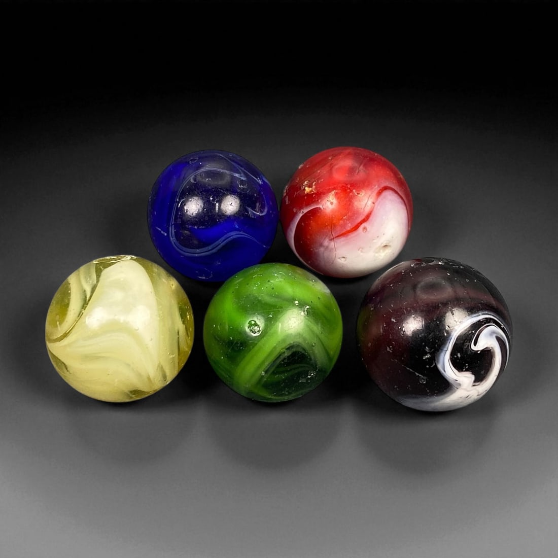 Vintage Glass Marbles Lot, Mid-20th Century, 1.6-1.7cm: This charming lot of vintage glass marbles, dating from the mid-20th century, reflects the artistry and playfulness of early handmade and molded glass craftsmanship. These marbles were produced during