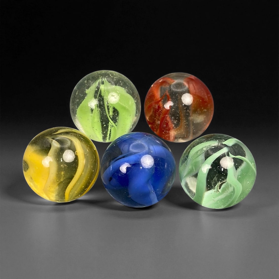 Vintage Glass Marbles Lot, Mid-20th Century, 1.5cm: This charming lot of vintage glass marbles, dating from the mid-20th century, reflects the artistry and playfulness of early handmade and molded glass craftsmanship. These marbles were produced during