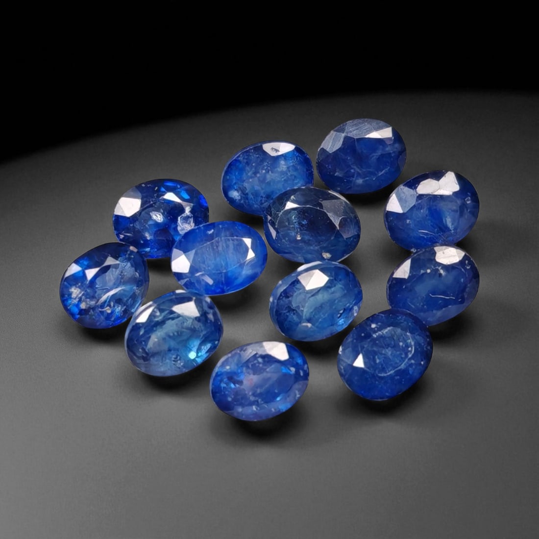 6.81 Carats Royal Blue Sapphire Oval Lot - Natural Ceylon Stones: This captivating lot of oval-cut sapphires exhibits a deep royal blue color, rich and even, with flashes of lighter brilliance across the facets. Each stone, measuring approximately 5x4.2x2.1mm, is gr