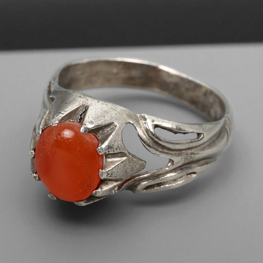 Antique Persian Carnelian Flame Motif Silver Ring, c. 19th-20th Century, US 9.5: This elegant antique silver ring reflects the refined artistry of late Qajar to early Pahlavi Persian jewelry, blending symbolism and design with poetic restraint. The centerpiece is a warm orange-red