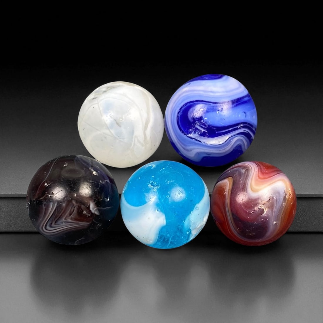 Vintage Glass Marbles Lot, Mid-20th Century, 1.5-1.7cm: This charming lot of vintage glass marbles, dating from the mid-20th century, reflects the artistry and playfulness of early handmade and molded glass craftsmanship. These marbles were produced during