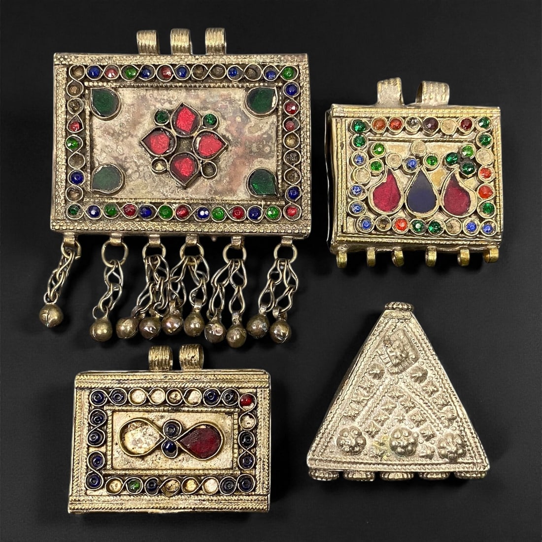 Antique Himalayan Silver Alloy Amulet Box Pendants Set, c. 19th-20th Century, 5-7.5 cm: This captivating set of four antique Himalayan amulet boxes, dating to the 19th-20th century, represents the region's deep spiritual and artistic heritage. Crafted in silver alloy and richly adorned w