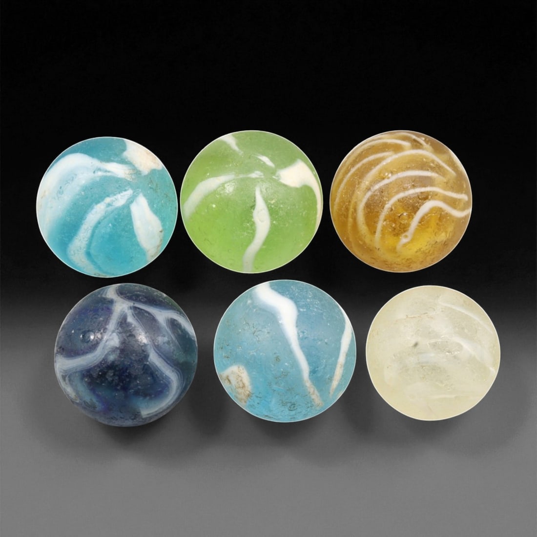 Vintage Glass Marbles Lot, Mid-20th Century, 2.2-2.5cm: This charming lot of vintage glass marbles, dating from the mid-20th century, reflects the artistry and playfulness of early handmade and molded glass craftsmanship. These marbles were produced during