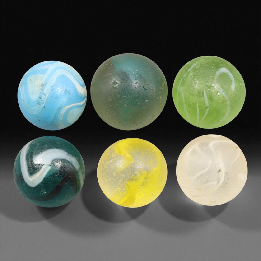 Vintage Glass Marbles Lot, Mid-20th Century, 2.2-2.5cm: This charming lot of vintage glass marbles, dating from the mid-20th century, reflects the artistry and playfulness of early handmade and molded glass craftsmanship. These marbles were produced during