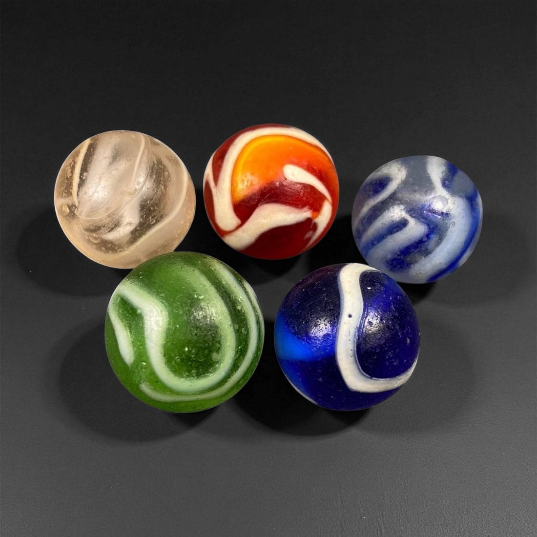 Vintage Glass Marbles Lot, Mid-20th Century, 1.5-1.6cm: This charming lot of vintage glass marbles, dating from the mid-20th century, reflects the artistry and playfulness of early handmade and molded glass craftsmanship. These marbles were produced during